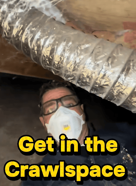Inspector wearing PPE and getting in the crawlspace to show those who are concerned about mold in their home how they need to look around to be thorough.