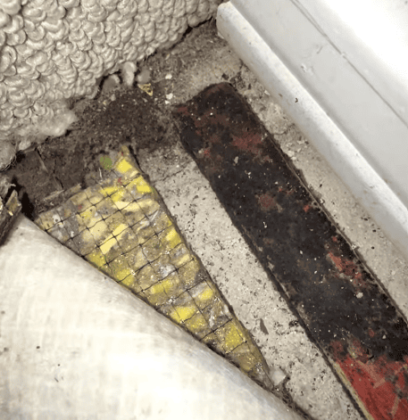 Mold-like growth and moisture-related staining visible along bathroom surfaces near plumbing fixtures.